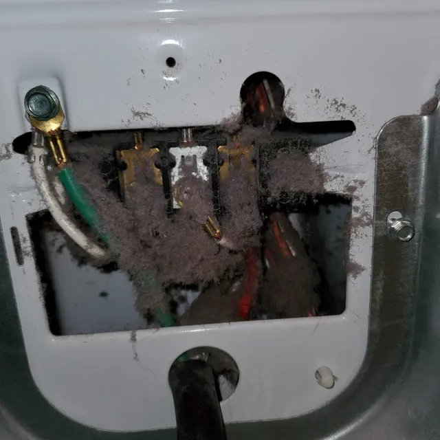 Lint packed around dryer power cord and electrical connection