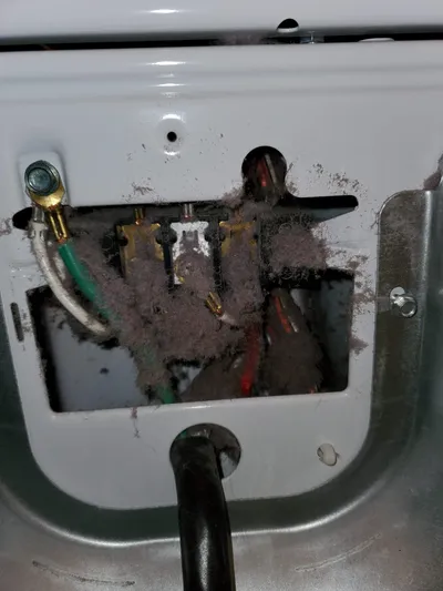Lint packed around dryer power cord and electrical connection