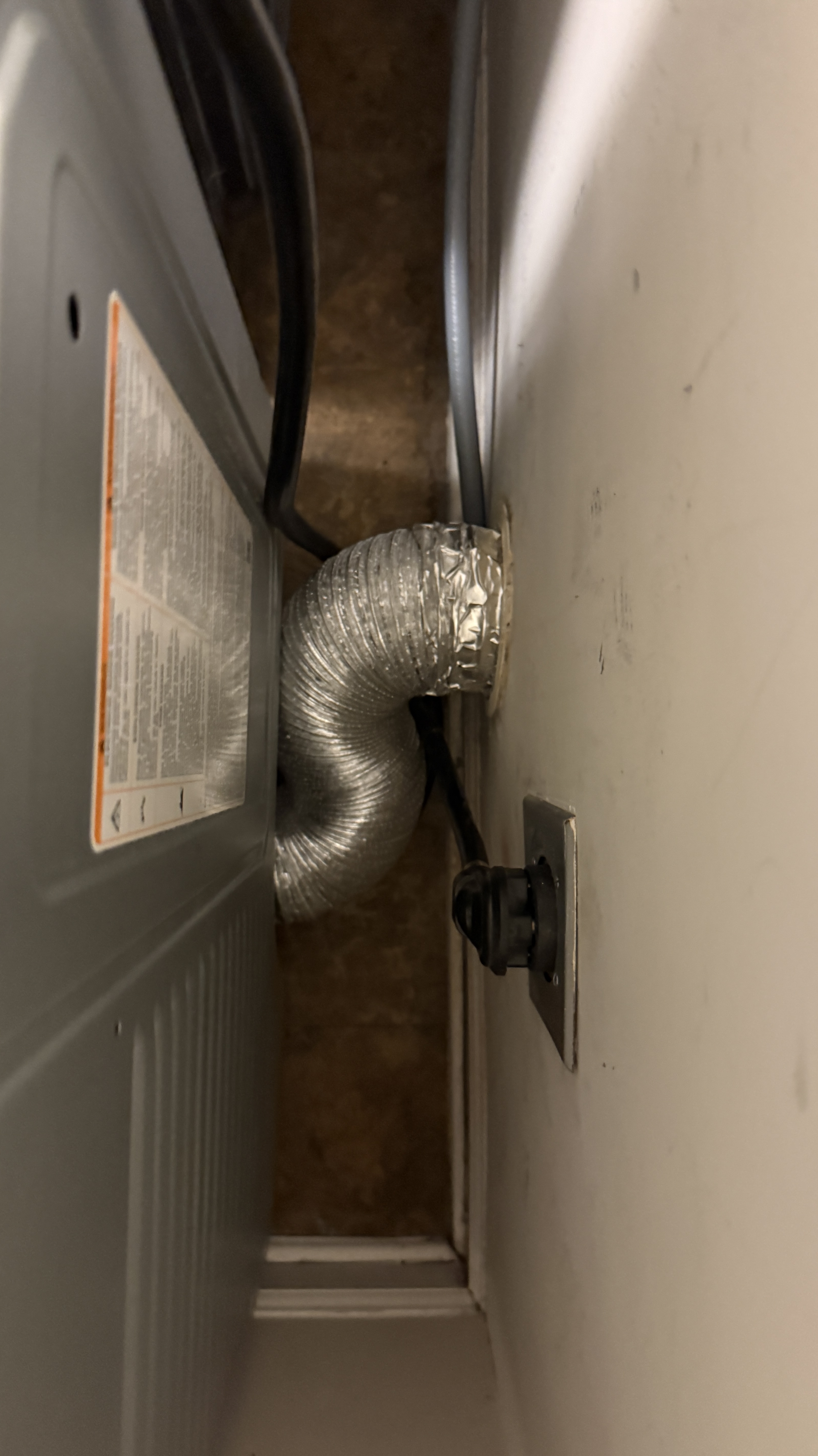 DryerFlex transition hose air-sealed from dryer exhaust to wall with clean laundry room floor