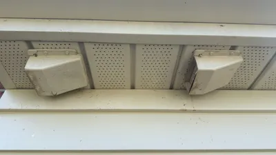 Broken bathroom soffit vent covers where birds and wasps were nesting in Burlington NC