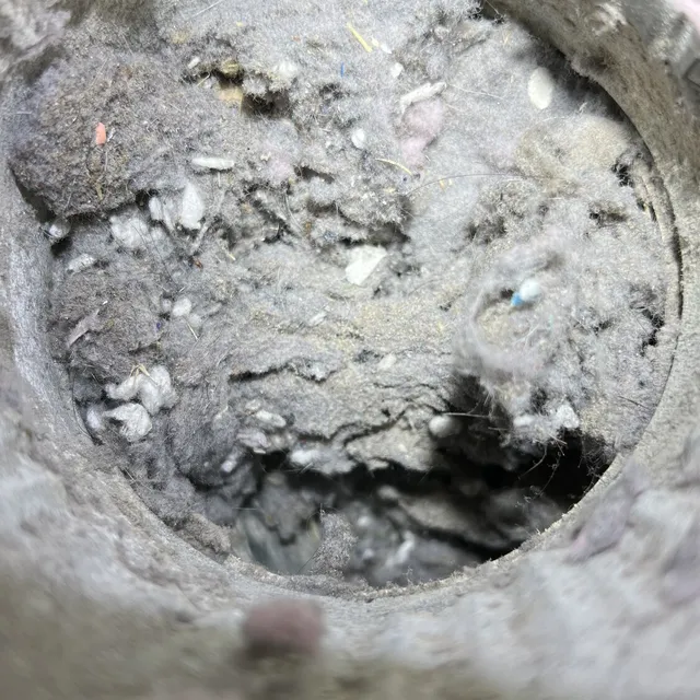 Clogged dryer vent pipe packed with lint in a Burlington NC home
