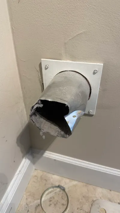 Crushed metal dryer vent stub from an overtightened clamp in Sunset Hills Greensboro