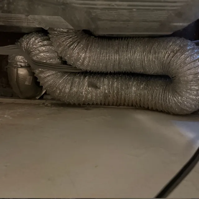 Tangled, kinked dryer transition hose restricting airflow behind dryer