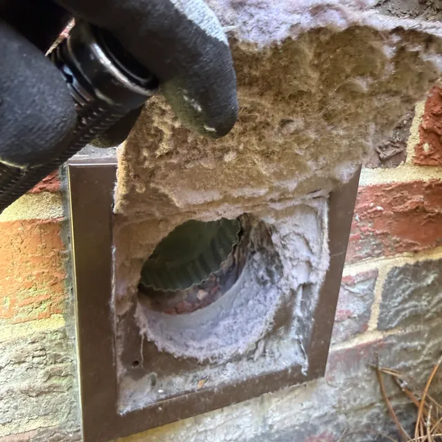 Lint packed on a dryer vent cover door in Old Irving Park Greensboro