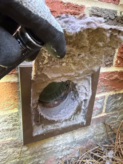 Lint packed on a dryer vent cover door in Old Irving Park Greensboro