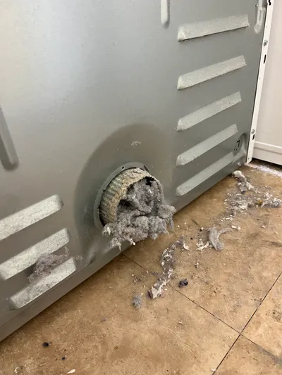 Lint backup at dryer exhaust path inside the machine
