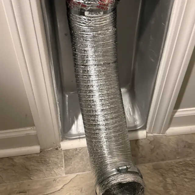 DryerFlex duct sealed with foil tape at wall connection in recessed dryer vent box