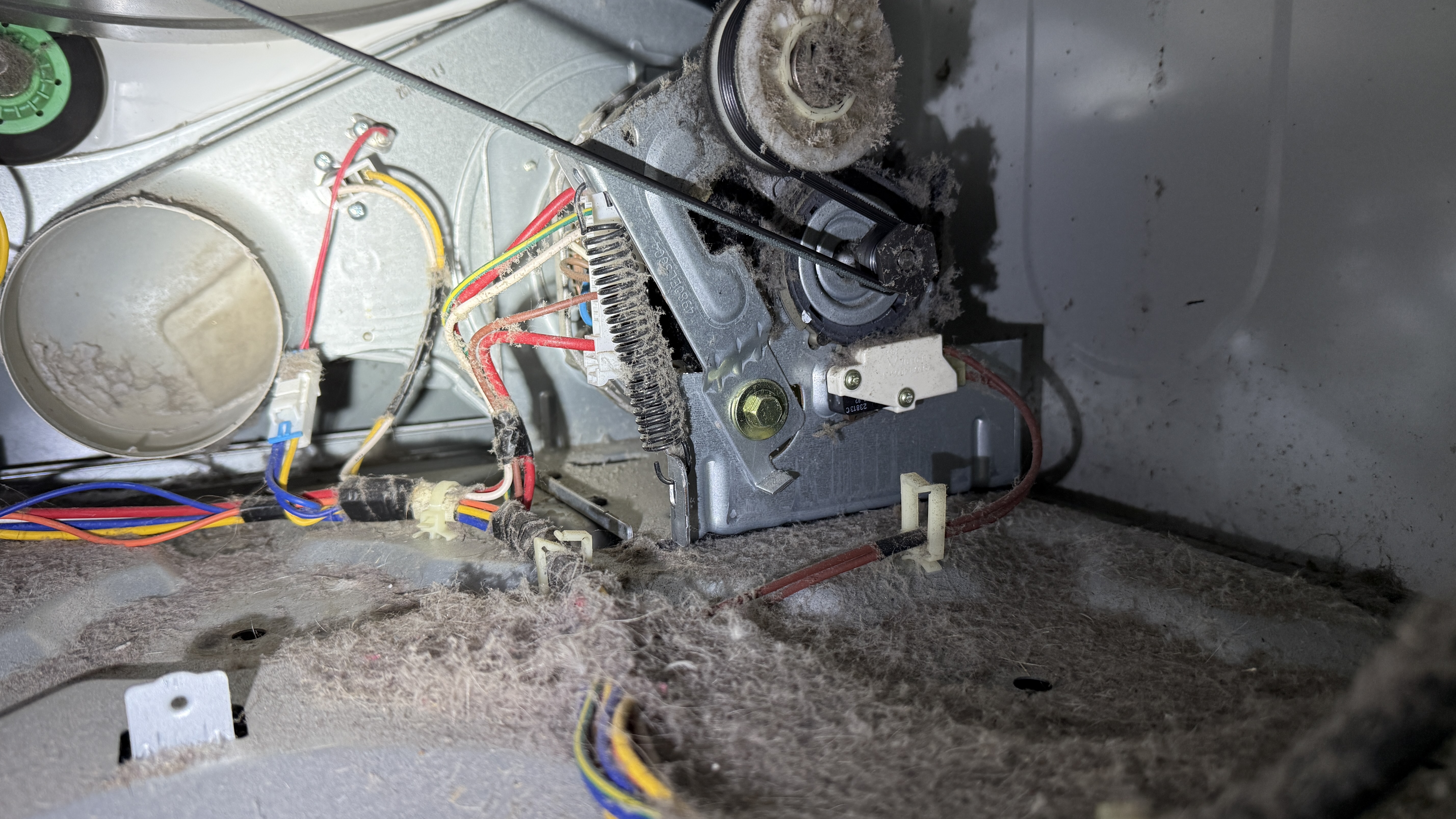 Dryer motor covered in lint dust inside the machine