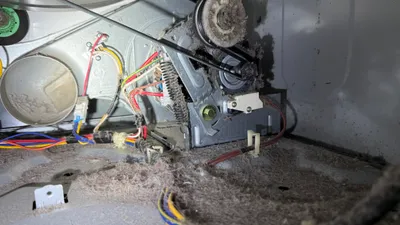 Dryer motor covered in lint dust inside the machine