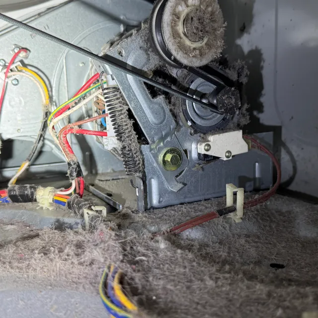 Dryer motor covered in lint dust inside the machine