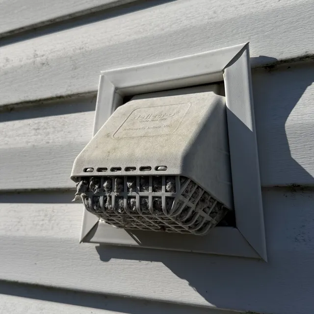 Builder enclosed bird guard on a Waterbury dryer vent clogged with lint
