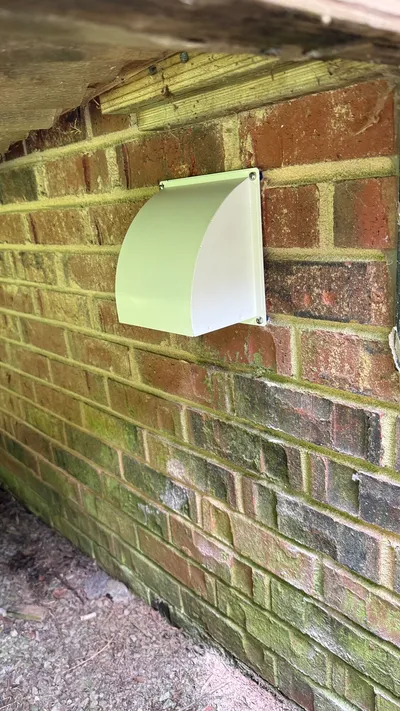 New pest-proof metal dryer vent cover under a deck in New Irving Park Greensboro