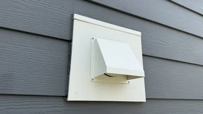 New pest resistant metal dryer vent cover on gray siding in Mackintosh on the Lake Burlington
