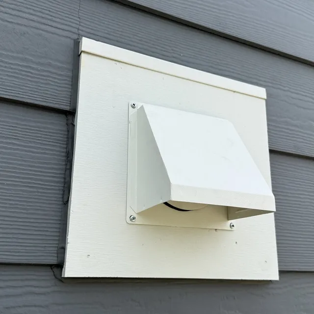New pest resistant metal dryer vent cover on gray siding in Mackintosh on the Lake Burlington