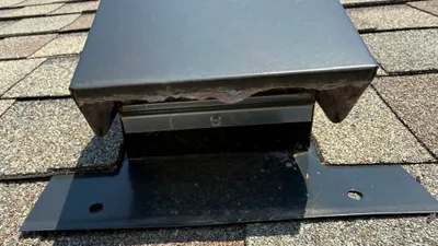 Clean metal dryer vent hood on a west Greensboro roof