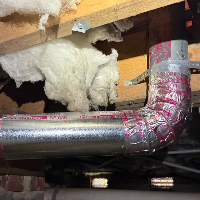 New metal dryer vent turn sealed with mastic and metal straps in a New Irving Park crawlspace