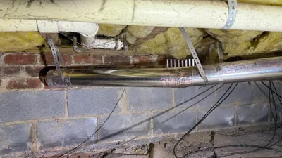 New metal dryer vent with metal strapping in a Northern Shores crawlspace