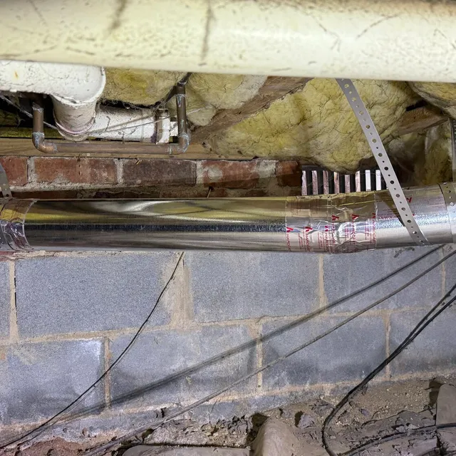 New metal dryer vent with metal strapping in a Northern Shores crawlspace