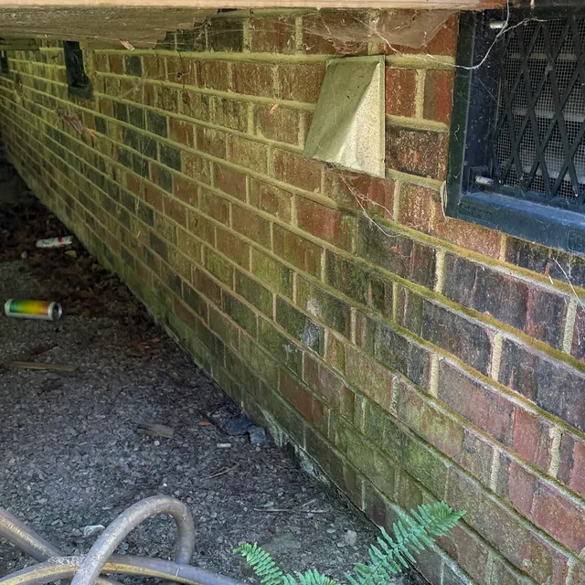 Old restrictive 70s dryer vent cover under a deck in New Irving Park Greensboro