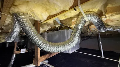 Sagging foil flex dryer vent on plastic hangers in a Creekridge crawlspace