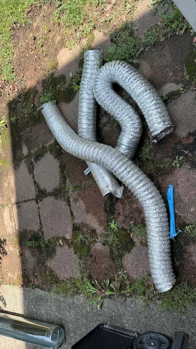 Foil flex dryer vent pulled from a New Irving Park crawlspace and laid on the walk