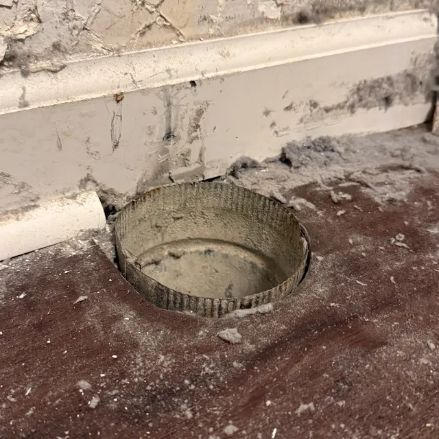 Dryer vent pipe cut too short at floor causing dust and lint leakage