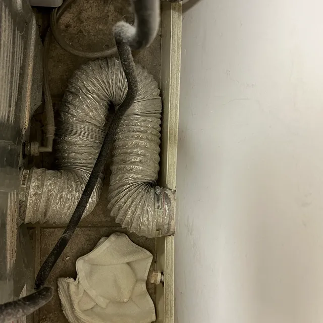 Poorly routed flexible dryer transition hose with dust behind the dryer