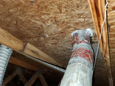Repaired dryer vent termination in attic with mastic seal