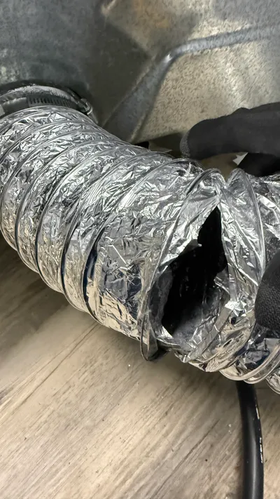 Torn flexible dryer transition duct leaking lint