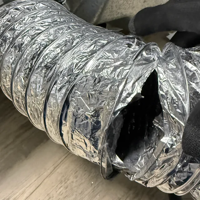 Torn flexible dryer transition duct leaking lint