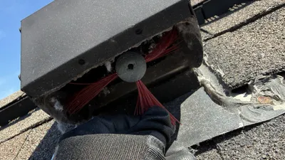 Dryer vent cleaning brush coming out of a roof vent cover in Mackintosh on the Lake Burlington