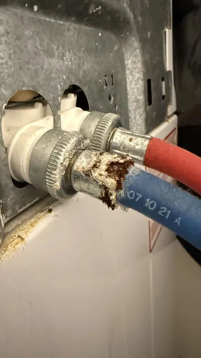 Rusted washer water line connections found during a dryer vent cleaning in Greensboro