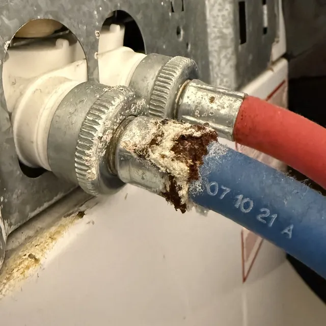 Rusted washer water line connections found during a dryer vent cleaning in Greensboro