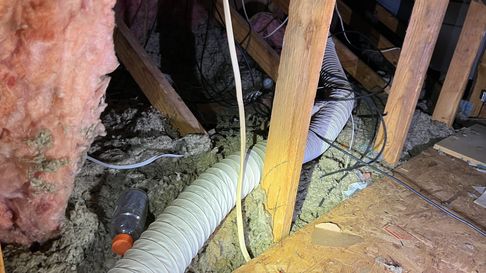 White plastic tubing behind dryer